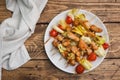 Kebab chicken, zucchini and tomatoes on skewers in a plate. Wooden table Royalty Free Stock Photo