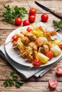 Kebab chicken, zucchini and tomatoes on skewers in a plate. Wooden table Royalty Free Stock Photo