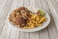 Kebab menu with falafel and sour cheese, with a portion of French fries, white onion salad, iceberg lettuce