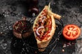 Kebab, pita, gyros, shaurma, wrap sandwich stuffed with sausages from minced meat with grilled meat, vegetables and sauce on dark Royalty Free Stock Photo