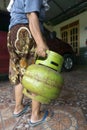 KEBUMEN, INDONESIA Ã¢â¬â JULY 29, 2021 : A mother was lifting a small LPG gas to take to the shop