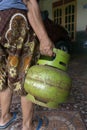 KEBUMEN, INDONESIA Ã¢â¬â JULY 29, 2021 : A mother was lifting a small LPG gas to take to the shop