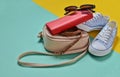 Keds, sunglasses, belt, purse, bag on a blue yellow pastel background. Women & x27;s accessories. Trend of minimalism Royalty Free Stock Photo