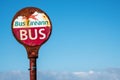 Keel town, county Mayo, Ireland - 28.05.2021: Old weathered Bus Eireann logo on a bus stop against blue cloudy sky Royalty Free Stock Photo