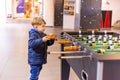 A keen and surprised boy plays table football Royalty Free Stock Photo