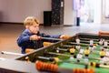 A keen and surprised boy plays table football Royalty Free Stock Photo