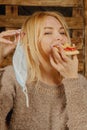 Keep calm and bon appetit! Young bold beautiful woman eating pizza without medicine respirator mask