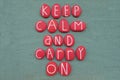 Keep Calm And Carry On, Creative Slogan Composed With Red Colored Stone Letters Over Green Sand