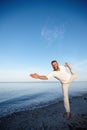 Keep calm and do yoga. Full length shot of a handsome mature man doing yoga on the beach. Royalty Free Stock Photo