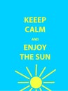 Keep calm and enjoy the sun motivational quote. Text on blue background.