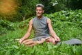 Man practicing yoga and doing ardha padmasana exercise while sitting on lotus position Royalty Free Stock Photo