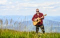 Keep calm and play guitar. Man hiker with guitar on top of mountain. Hiker enjoy nature. Musician hiker find inspiration Royalty Free Stock Photo