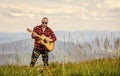 Keep calm and play guitar. Man hiker with guitar on top of mountain. Hiker enjoy nature. Musician hiker find inspiration Royalty Free Stock Photo