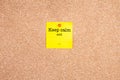 Keep calm and... on a yellow sticky note on cork board Royalty Free Stock Photo