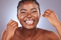 Keep it clean and flossed. a young woman flossing her teeth while standing against a studio background. Royalty Free Stock Photo