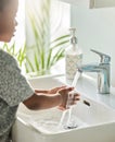 Keep clean, stay healthy. Closeup shot of an unrecognisable boy washing his hands at a tap in a bathroom at home. Royalty Free Stock Photo