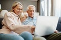 Keep that connection going. a mature couple using a laptop on the sofa at home. Royalty Free Stock Photo