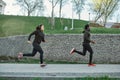 Keep distance. Athletic dark skinned couple in black sportswear running together in the park. Morning cardio. African Royalty Free Stock Photo