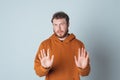 Keep distance. Serious concerned bearded young man shows block stop gesture, tell no, decline or reject offer Royalty Free Stock Photo