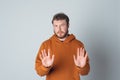 Keep distance. Serious concerned bearded young man shows block stop gesture, tell no, decline or reject offer Royalty Free Stock Photo