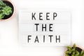 Keep the Faith, text written on a light box. Decorated with cactus Royalty Free Stock Photo