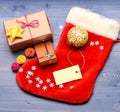 Keep family traditions. Stocking stuffers idea. Stocking with christmas gift box. Christmas sock toned wood background