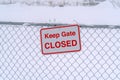 Keep Gate Closed sign on a wire fence against snow Royalty Free Stock Photo