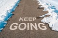 Keep going motivational message on asphalt road