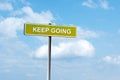 Keep Going. Road sign against a blue cloudy sky. Achievement of the goal. Achieving success