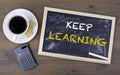Keep Learning. Chalk board on a wooden table Royalty Free Stock Photo