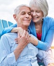 Keep love in your heart. an affectionate senior couple relaxing on chairs together outside.