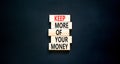 Keep more of your money symbol. Concept words Keep more of your money on wooden block. Beautiful black table black background.