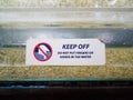 Keep off sign do not put fingers in water on fish tank Royalty Free Stock Photo