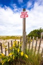 A Keep Off sign and fence on fragile sand dunes Royalty Free Stock Photo