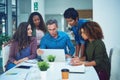 We keep our promise of giving the client the best. a group of designers gathering around a man using a laptop in a Royalty Free Stock Photo