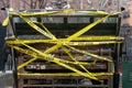 Keep out - Work area tape is wildly draped across an old, rusty, dirty dumpster container