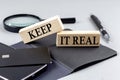 KEEP IT REAL text on wooden block on black notebook , business concept Royalty Free Stock Photo