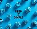 Keep it simple message with crumpled blue paper balls on blue background Royalty Free Stock Photo