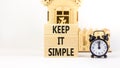Keep it simple symbol. Concept word Keep it simple on beautiful wooden block. Black alarm clock. Beautiful white table white Royalty Free Stock Photo