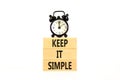 Keep it simple symbol. Concept word Keep it simple on beautiful wooden block. Black alarm clock. Beautiful white table white Royalty Free Stock Photo