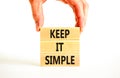 Keep it simple symbol. Concept word Keep it simple on beautiful wooden block. Businessman hand. Beautiful white table white