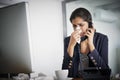 Keep strong and beat this cold. a young businesswoman making a call while blowing her nose and working in the office. Royalty Free Stock Photo