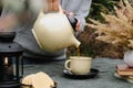 Keep warm, fall tea party. Autumn mood. Female hands pouring tea in mug, drinking tea outdoors. Royalty Free Stock Photo