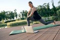 Keep yoga in daily routine. Athletic beautiful middle aged woman exercising on a mat while watching instructional videos