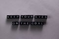 Keep your eyes on the goal on wooden blocks. Motivation and inspiration concept