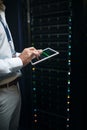Keeping all data safe and secure. Closeup shot of an unrecognisable man using a digital tablet while working in a server Royalty Free Stock Photo