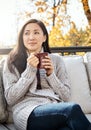 Keeping the autumn chill away with a cuppa coffee. an attractive young woman having a relaxing coffee break on an autumn