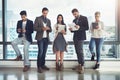 Keeping busy and focused on success. a diverse group of businesspeople using wireless technology in an office. Royalty Free Stock Photo