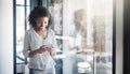 Keeping a close connection to all her clients. a young businesswoman using a cellphone in an office.