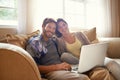 Keeping connected as a couple. Cropped portrait of a happy young couple using a laptop at home.